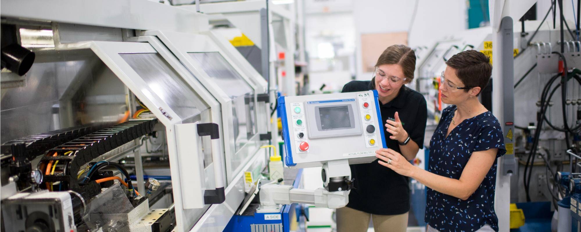 Two women working on a machine